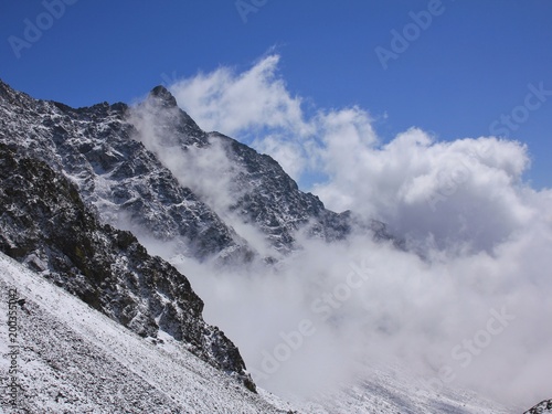 View from the Laurebina La mountain pass, Nepal. Clouds creeping over a mountain peak. photo