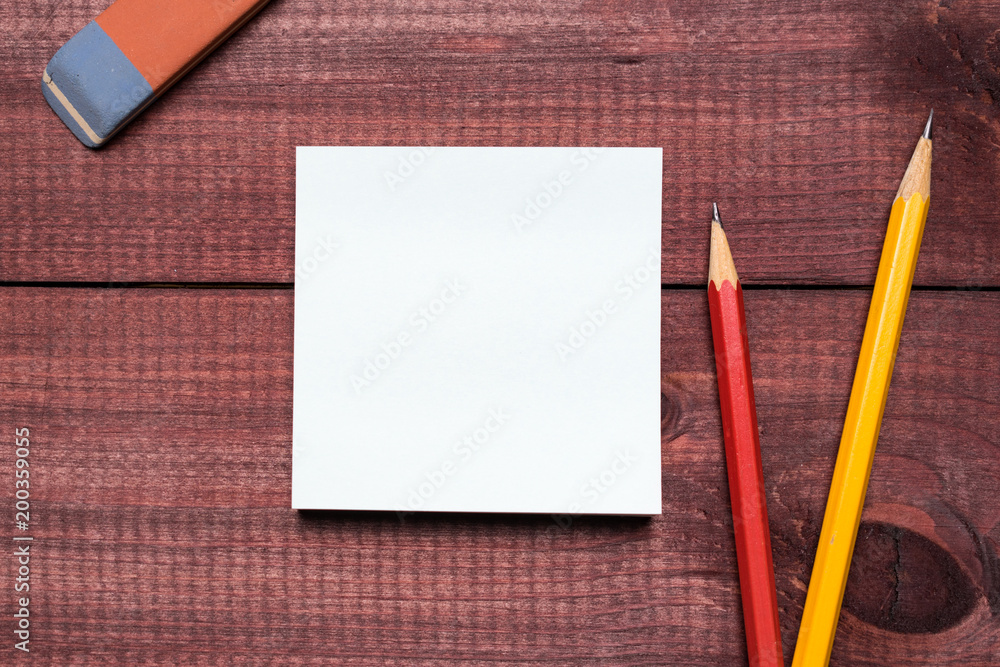 Sticky notes next to a blank sheet of paper. Supplies stationery on a wooden texture table. Trendy minimalism. Top view Sticky notes next to a blank sheet of paper. Supplies stationery on a wooden texture table. Trendy minimalism. Top view