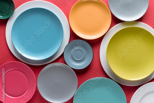 Stacks of colorful porcelain plates on red background photo