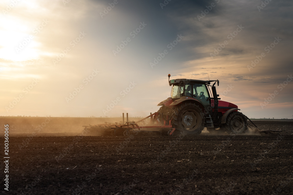 Fototapeta premium Tractor plowing fields -preparing land for sowing in autumn