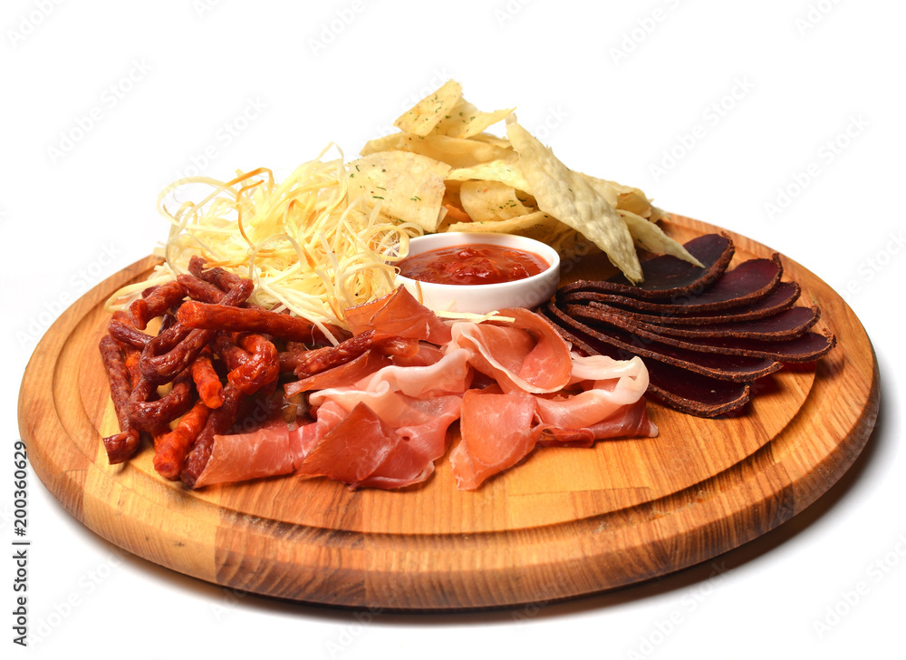 Snack to beer on a wooden board. Basturma, dried meat, dried squid, chips isolated on white background.