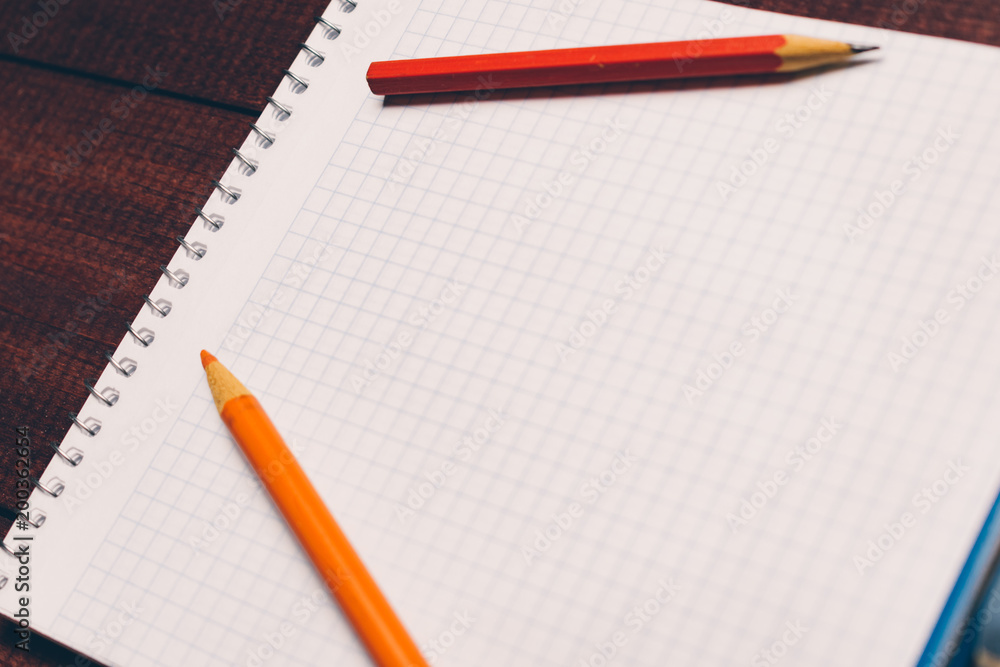 Bright used colorful pencils next to a blank sheet of paper. Work supplies stationery on a wooden texture table. Trendy minimalism. Concept of a modern freelancer workplace. Rustic cozy atmosphere Bright used colorful pencils next to a blank sheet of paper. Work supplies stationery on a wooden texture table. Trendy minimalism. Concept of a modern freelancer workplace. Rustic cozy atmosphere