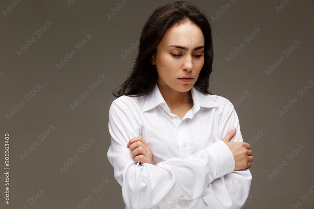 Beautiful girl in a white shirt shows emotions - disorder. On a light background. Beautiful girl in a white shirt shows emotions - disorder. On a light background.