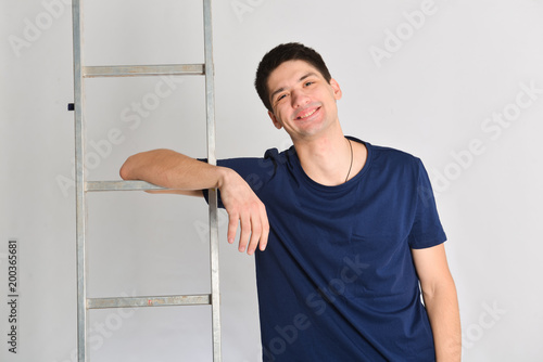 smile man posing near ladder. repair, design, constructor photo