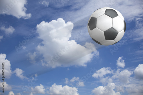 Klassischer Fu  ball aus Leder fliegend vor dem blauen Himmel mit Wolken