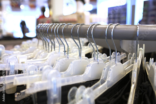 White hangers on the round rack placed sort of chaotically in a shop, DOF.