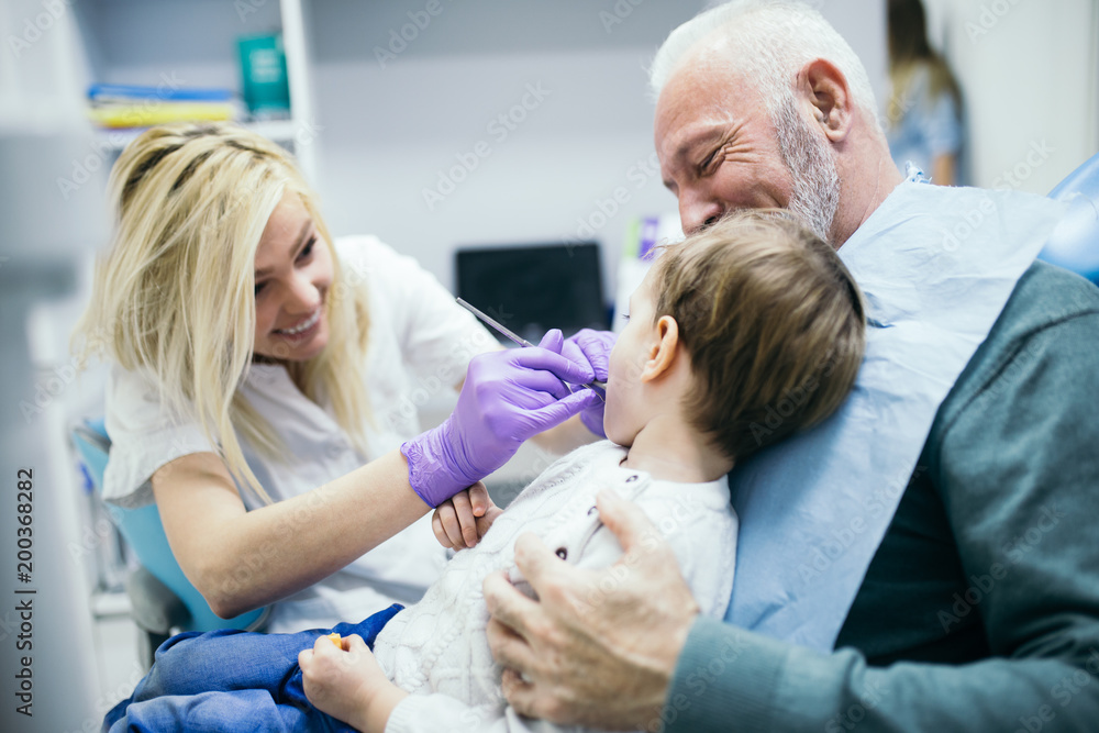 Two years old boy with his grandfather first time on dental chair Two years old boy with his grandfather first time on dental chair