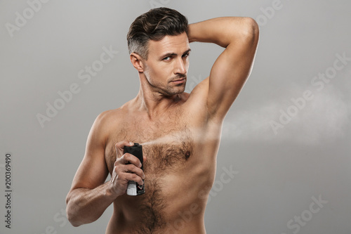 Mature man standing holding deodorant.