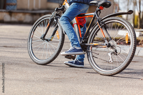 Child on a bicycle at asphalt road in sunny spring day