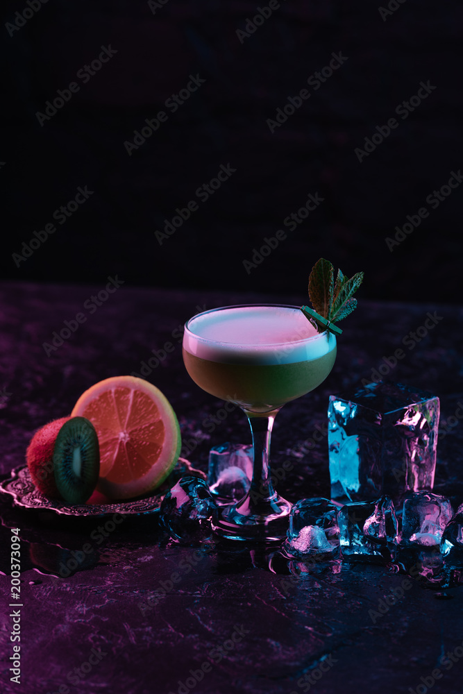 glass of delicious kiwi gin sour cocktail with ice cubes and sliced citrus fruits glass of delicious kiwi gin sour cocktail with ice cubes and sliced citrus fruits