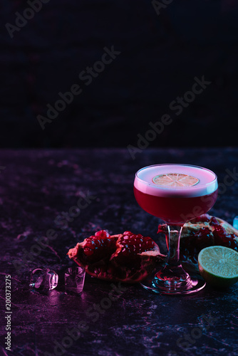 close-up view of conchita cocktail in glass with ingredients on dark surface photo