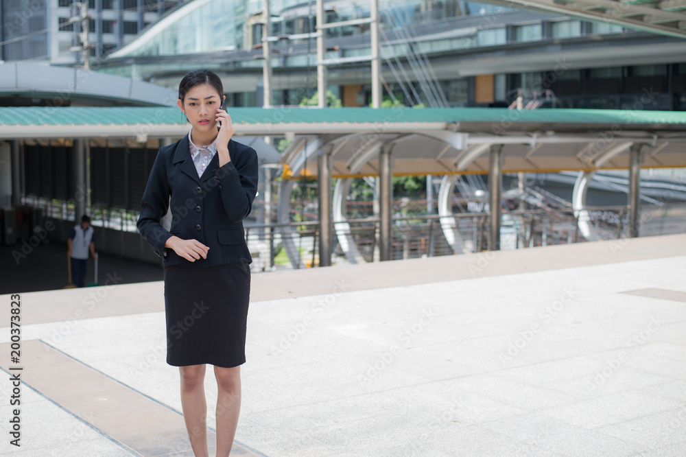 Asian business woman hold cell phone to talk about business plan, and copy space for text Asian business woman hold cell phone to talk about business plan, and copy space for text
