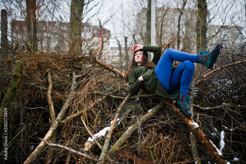 Wallpaper Mural Young girl wear on long green sweatshirt, jeans and black headwear at  branches of the pine tree in winter day. Torontodigital.ca