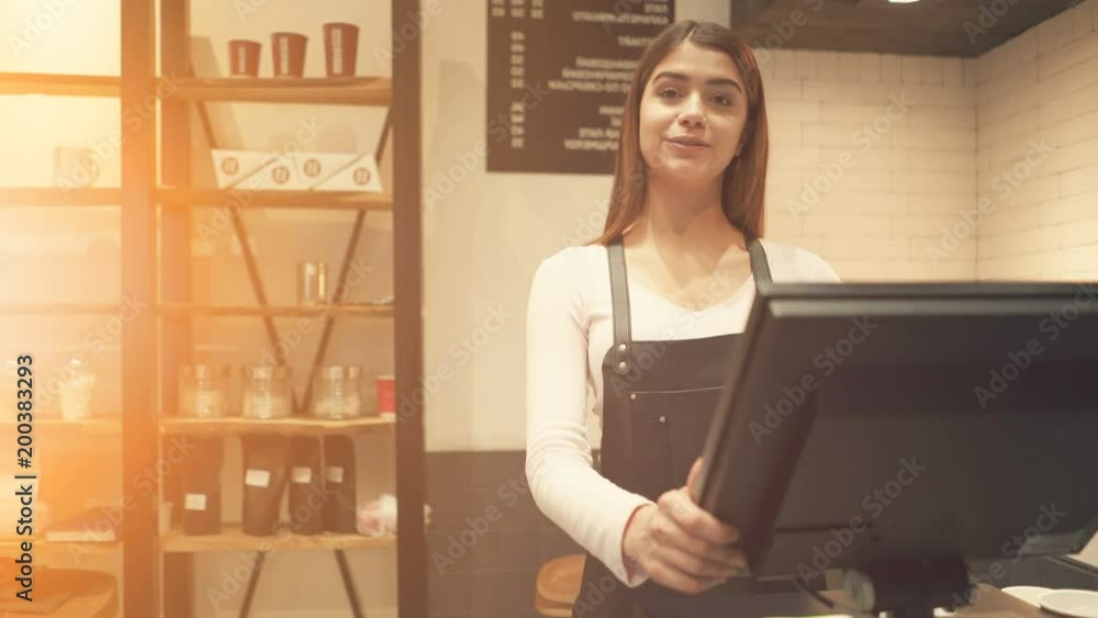 The cafe worker serves the customer at the counter The cafe worker serves the customer at the counter