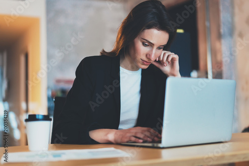 Young beautiful businesswoman using laptop computer at modern office.Blurred background.Horizontal.