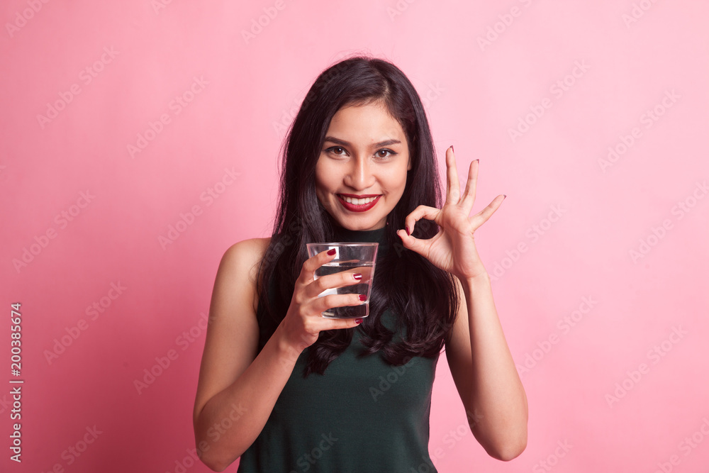 Young Asian woman show OK with a glass of drinking water. Young Asian woman show OK with a glass of drinking water.