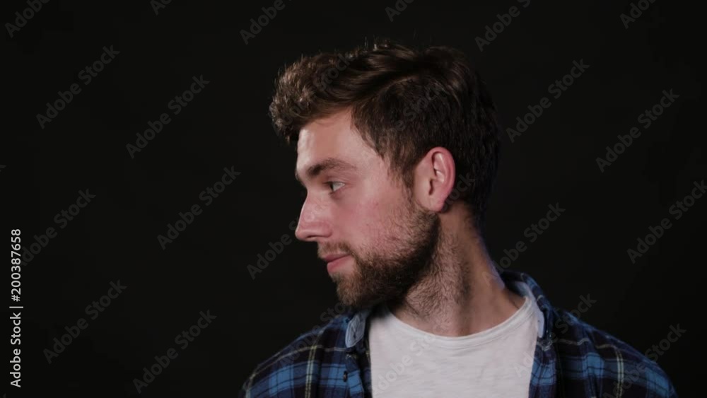 A young man's face against a black background. Close-up shot A young man's face against a black background. Close-up shot