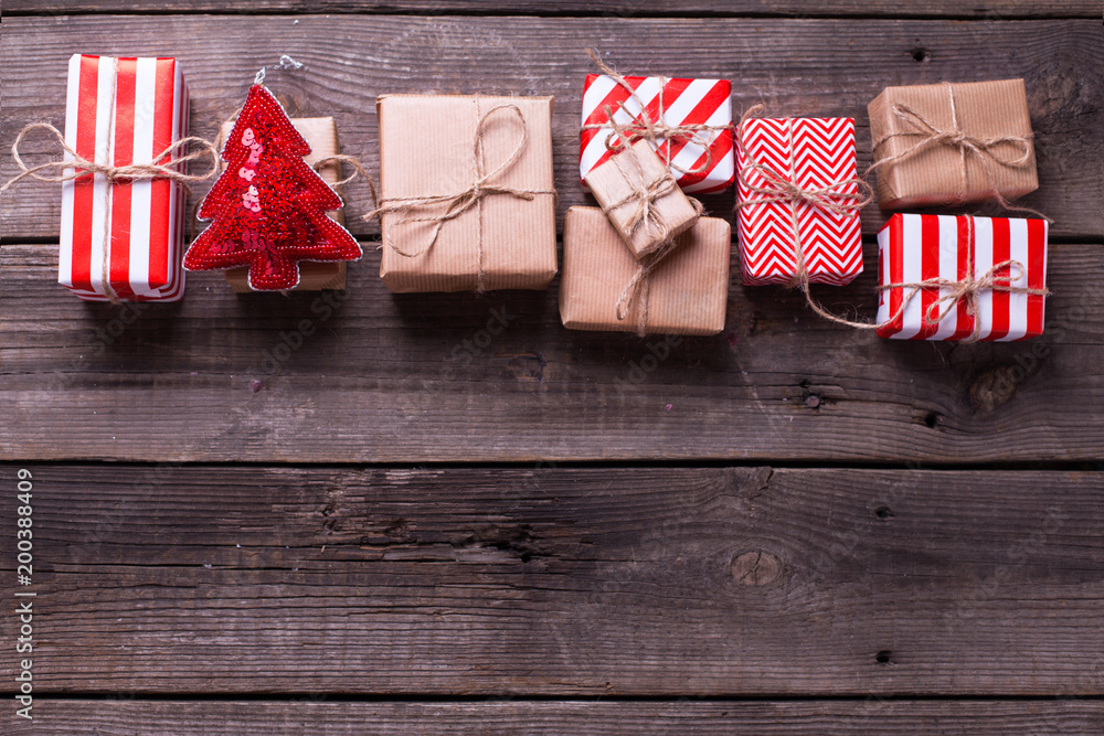 Fototapeta premium Border from gift boxes with presents and toy in form of tree on vintage wooden background