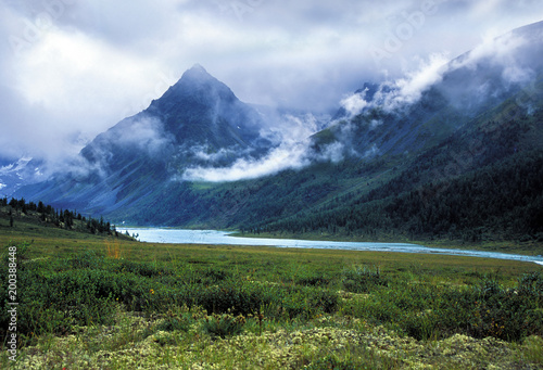 Mountain peak in clouds across the river. Ak-kem valley , Altai 