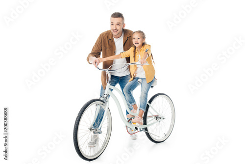 smiling father and little daughter on bicycle isolated on white