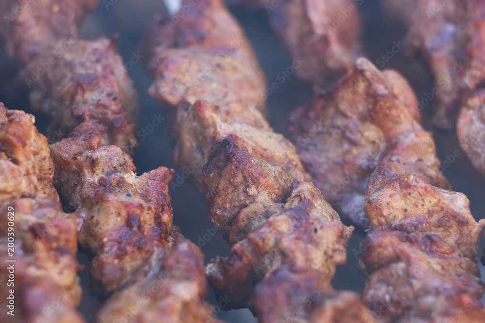 Fresh meat shish kebab fried and smoked on a charcoal grill. Roast the meat close up Fresh meat shish kebab fried and smoked on a charcoal grill. Roast the meat close up