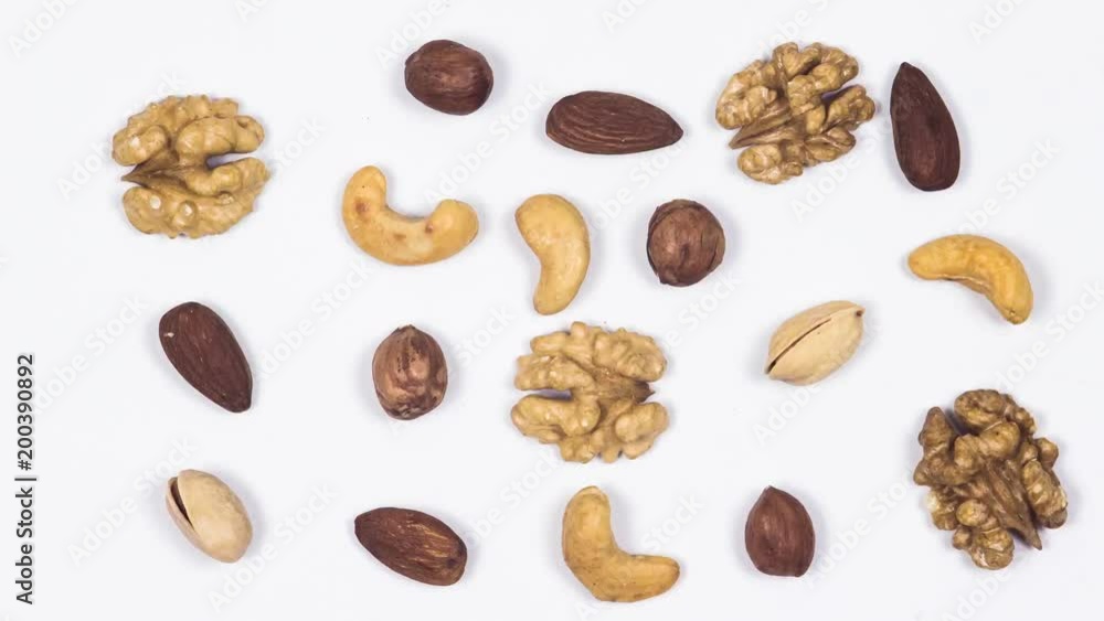 Nuts move on a white table. Pistachio, hazelnuts, almonds,cashew, peanuts, walnuts. Stop motion. 4k Nuts move on a white table. Pistachio, hazelnuts, almonds,cashew, peanuts, walnuts. Stop motion. 4k