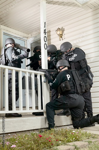 Φωτογραφία Police tactical team gathered round a house