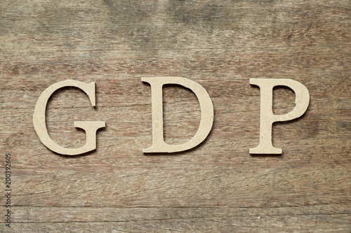 English alphabet in word GDP (Abbreviation of good distribution practice or gross domestic product) on wood background