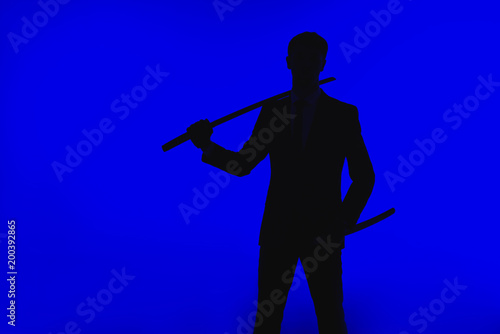 toned picture of silhouette of agent in suit with Katana
