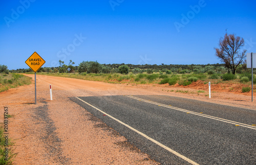 Yellow sign gravel road. Caution the end of a good road. Ended asphalt, the beginning of off road terrain. Attention finish road bitumen.