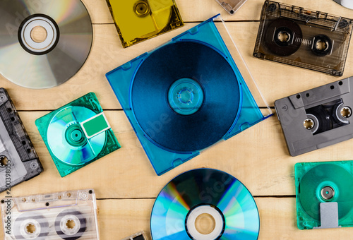 cassette discs and floppy disks for music lie on a wooden table