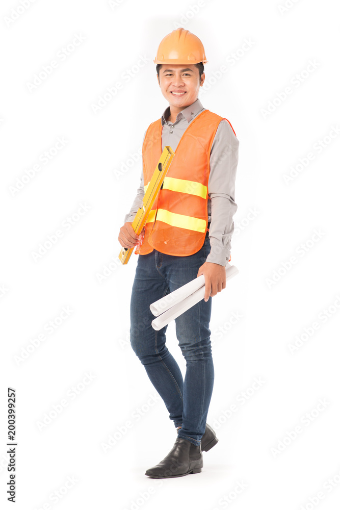 Studio portrait of construction worker in orange waistcoat and hardhat holding levelling tool and building plan Studio portrait of construction worker in orange waistcoat and hardhat holding levelling tool and building plan