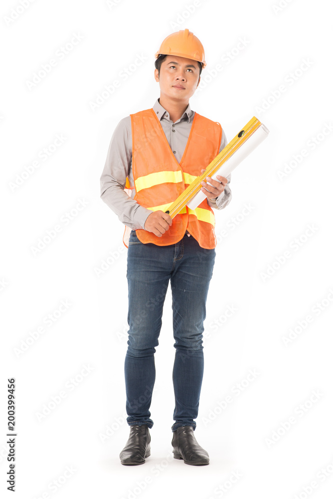 Studio portrait of construction worker in orange waistcoat and hardhat holding levelling tool and building plan Studio portrait of construction worker in orange waistcoat and hardhat holding levelling tool and building plan