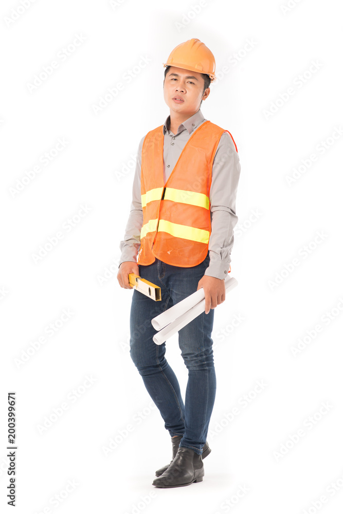 Studio portrait of construction worker in orange waistcoat and hardhat holding levelling tool and building plan Studio portrait of construction worker in orange waistcoat and hardhat holding levelling tool and building plan