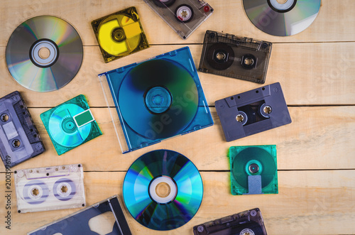 Music cassettes and music CDs lie on a wooden table