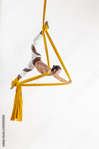 Man making acrobatic dance with fabrics