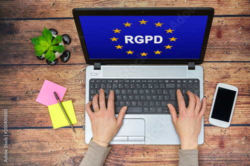 Woman using a computer with Flag of European Union with RGPD word inside on the screen photo