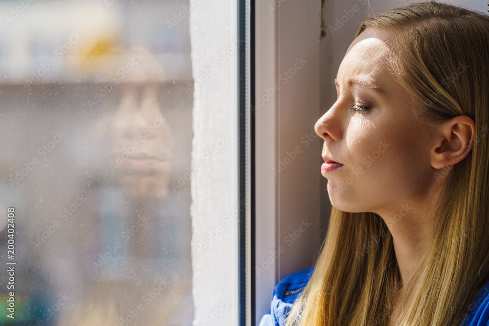 Woman relaxing on windowsill Woman relaxing on windowsill