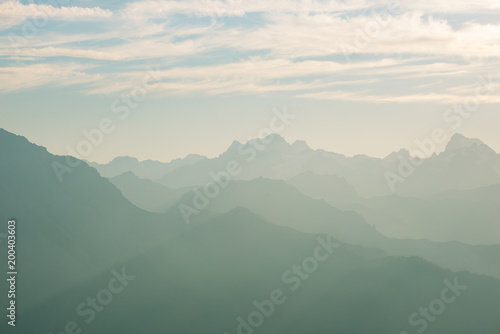 Distant mountain silhouette with clear sky and soft light. Toned image, vintage filter, split toning. © fabio lamanna