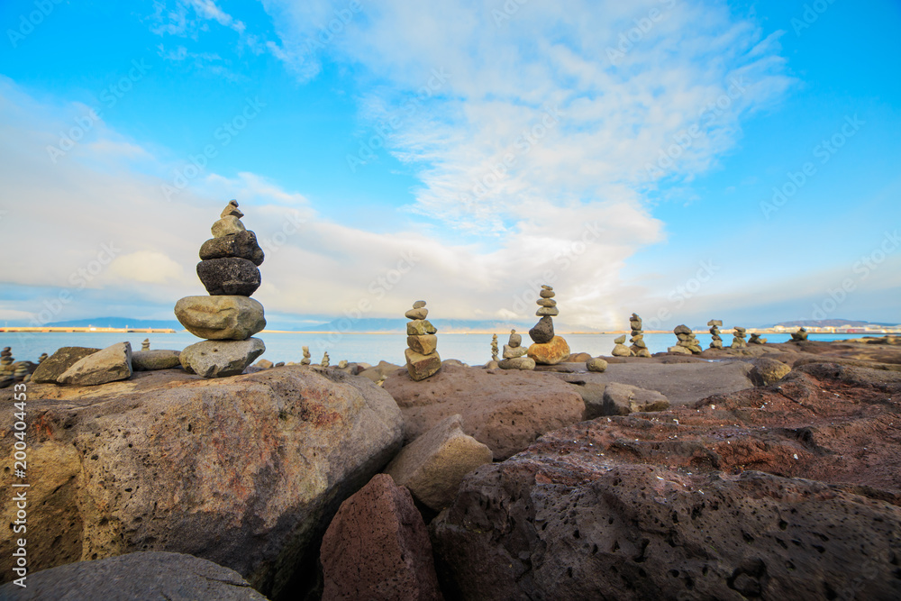 Series of stacked rock columns called cairns facing the sea in Reykjavik, Iceland. 