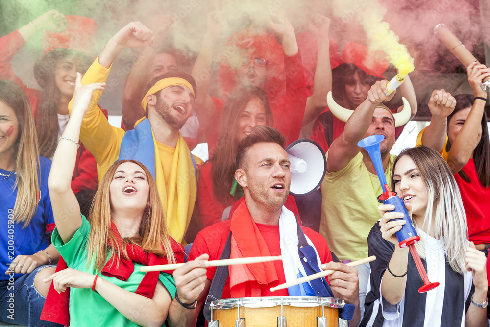 group of fans dressed in red color watching a sports event