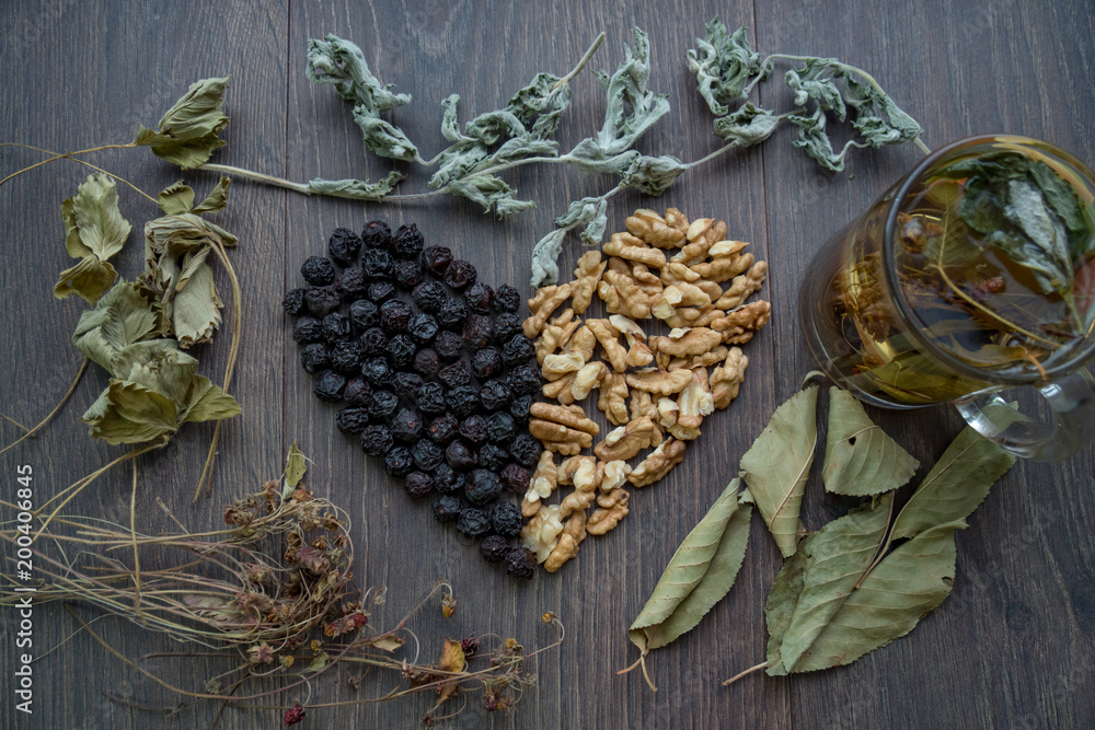 heart of dried cherries, nuts and dried leaves of tea, cup of herbal tea on the windowsill heart of dried cherries, nuts and dried leaves of tea, cup of herbal tea on the windowsill