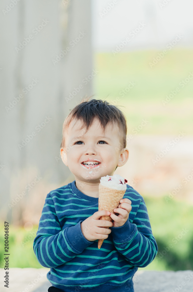 baby eating ice cream outdoors on grass background baby eating ice cream outdoors on grass background