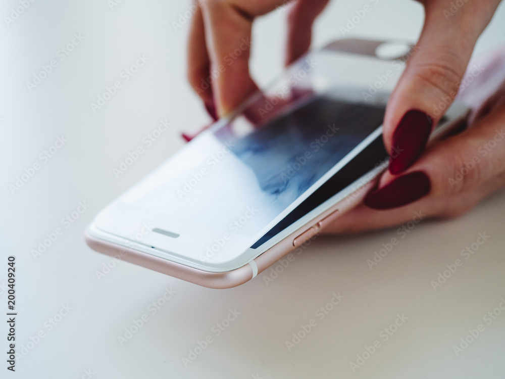 Smartphone with screen protect glass cover in hands. White background Smartphone with screen protect glass cover in hands. White background