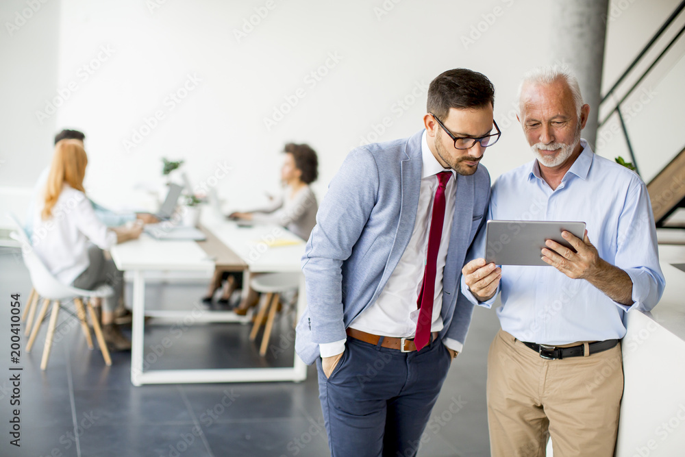 Businessmen with digital tablet in office Businessmen with digital tablet in office