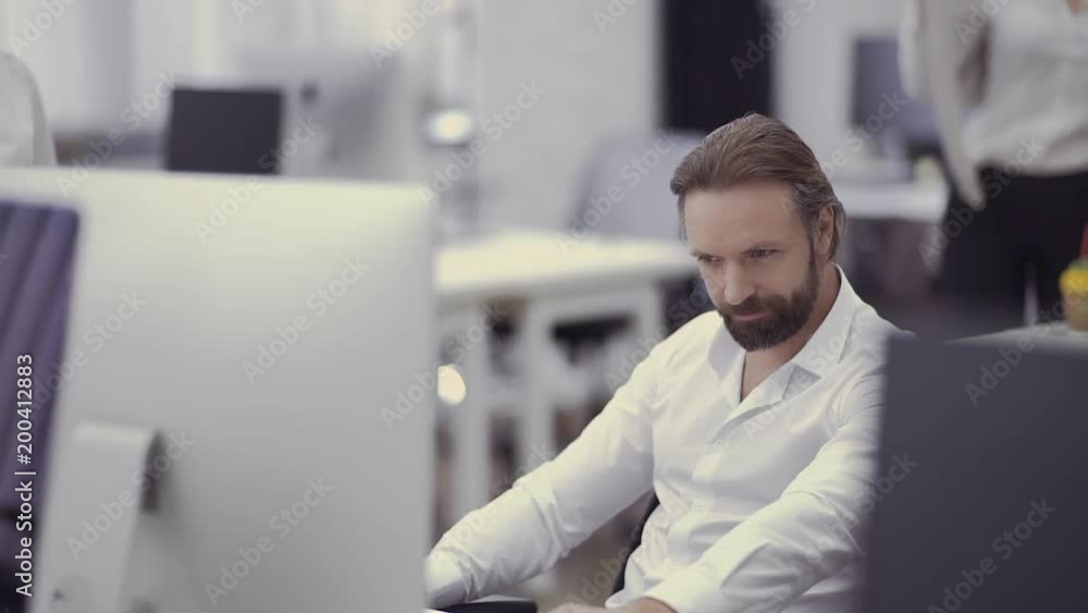 Handsome businessman works at the computer in the office Handsome businessman works at the computer in the office