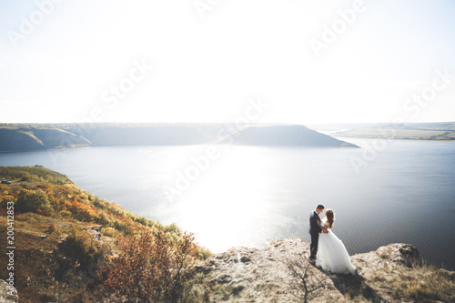 Happy wedding couple staying over beautiful landscape