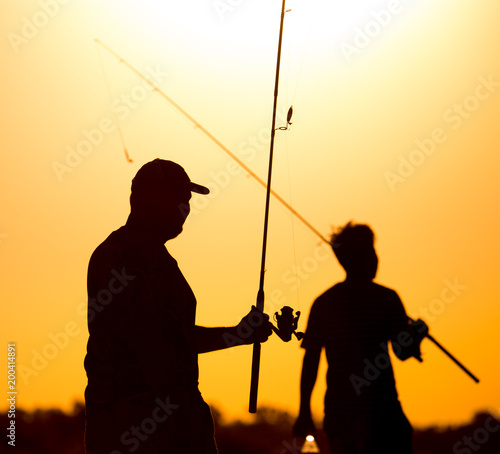 Fisherman with a fishing rod at sunset