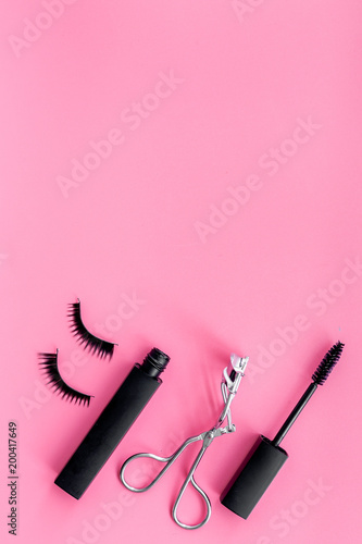 Fototapeta Naklejka Na Ścianę i Meble -  Makeup set for expressive eyelashes. Mascara, false eyelashes, eyelash curler on pink background top view space for text