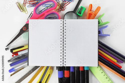 opened Notepad on office supplies on white background